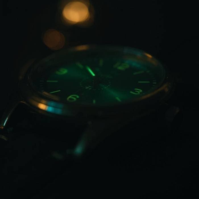 Close-up of a vintage watch dial glowing green